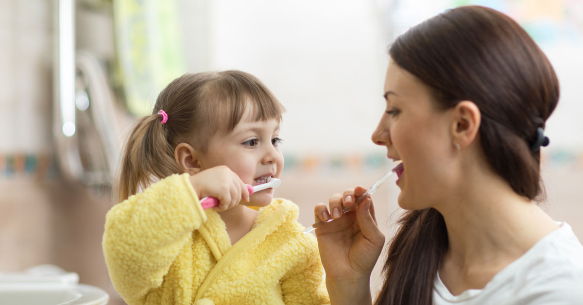 mom and daughter brushing teeth