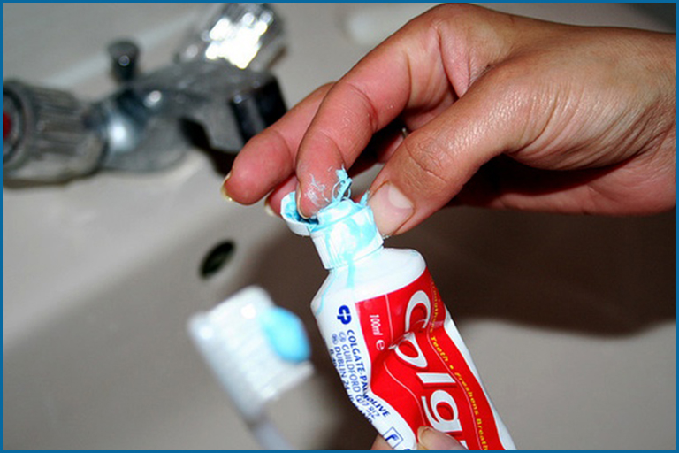 rubbing toothpaste on teeth