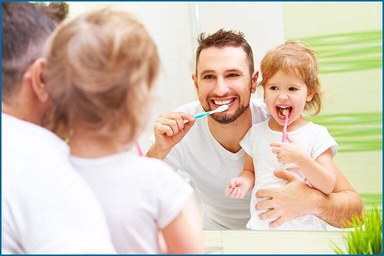kid brushing with her father