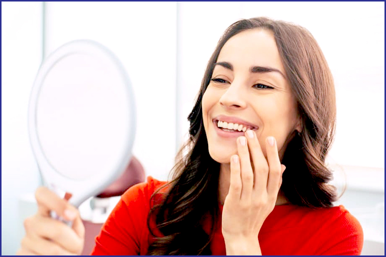 women looking at mirror and enjoying her smile